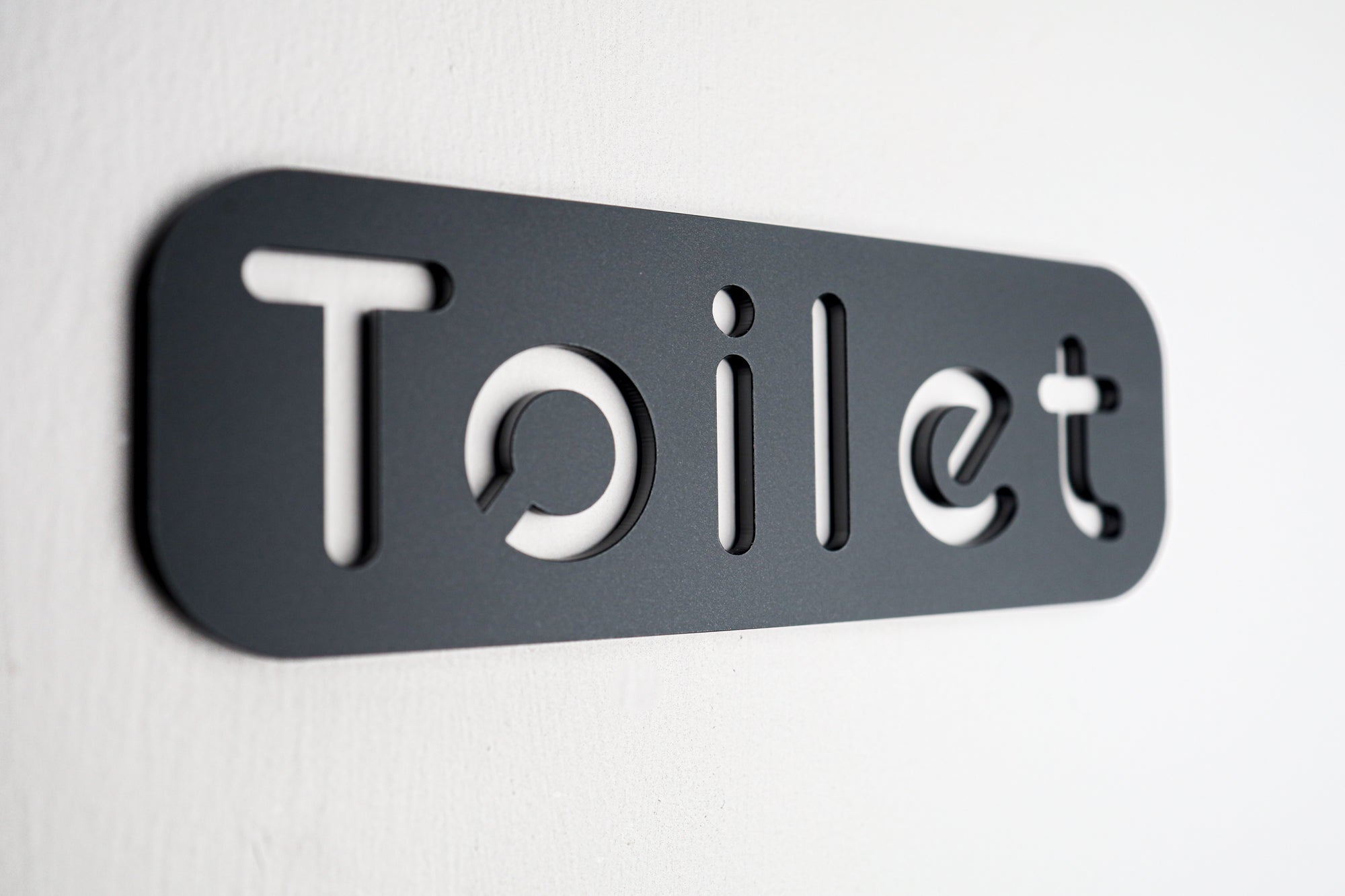 Minimalist black WC sign with modern design on a bathroom door