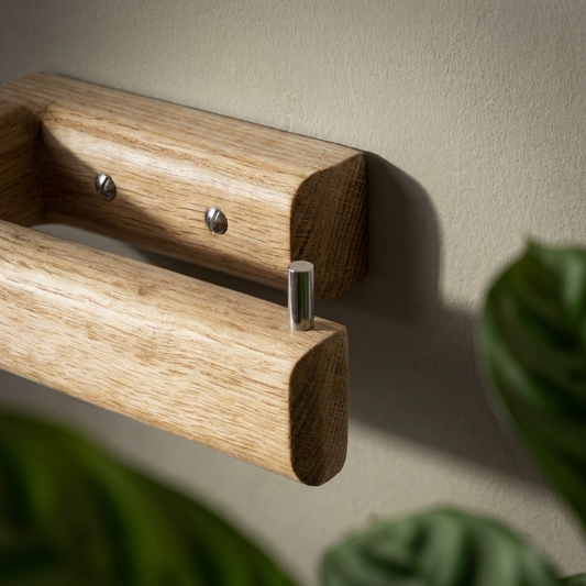 Wooden toilet paper holder with a plant in the foreground