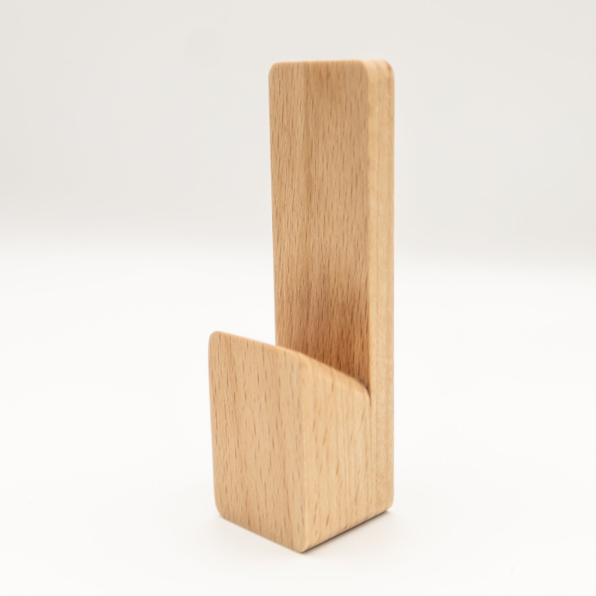 Minimalist beech wood hook holding a towel in guest toilet